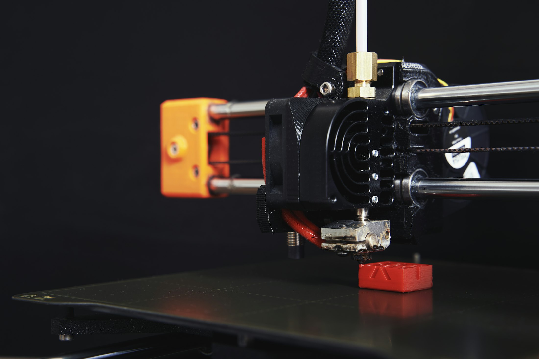 A 3D printer head above a part being printed